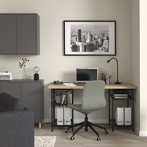Moderna oficina en casa con escritorio negro LAGKAPTEN, silla gris, lámpara, monitor y arte del horizonte de la ciudad.