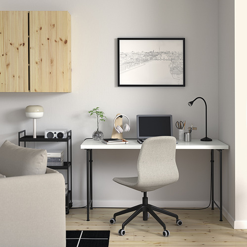 Espacio de trabajo minimalista: escritorio blanco LAGKAPTEN, silla, plantas, mapa, estantería, sofá.