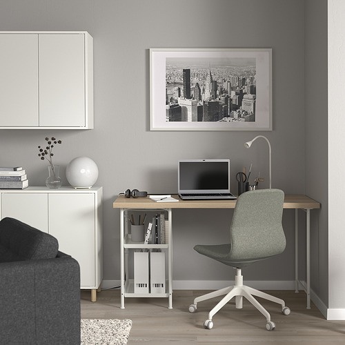 Moderna configuración de oficina en casa gris con escritorio LAGKAPTEN blanco, silla verde y obras de arte de paisajes urbanos en blanco y negro, perfectas para trabajar o estudiar.