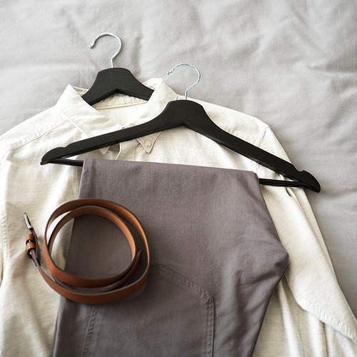 Camisa y pantalones en perchas, cinturón enrollado.