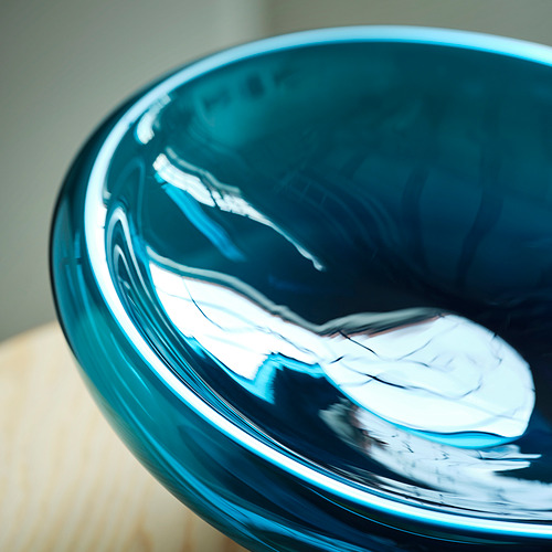 Cuenco de vidrio azul, superficie reflectante, forma orgánica.