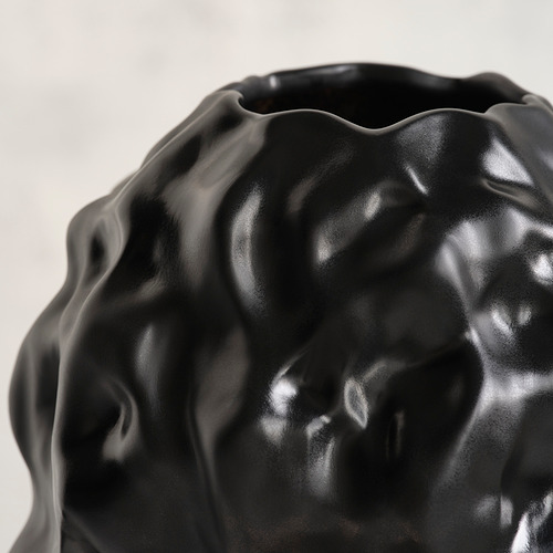 Jarrón escultórico de gres negro con textura brillante y burbujeante.