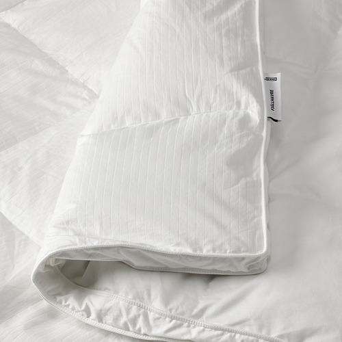 Un lujoso edredón de plumas blancas de ikea FJÄLLHAVRE, cuidadosamente doblado con paredes laterales cosidas para mejorar la calidez y la esponjosidad.