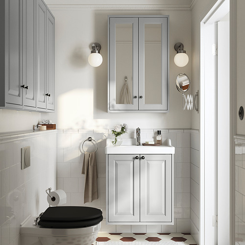 Baño moderno: azulejos blancos, armario gris, espejo, lavabo, inodoro. El lavabo RUTSJÖN encaja bien.