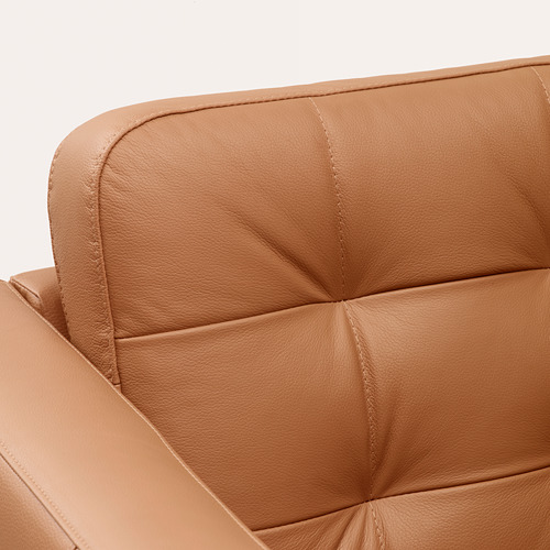 Primer plano de un moderno sillón de cuero tostado con un diseño adaptable que destaca la artesanía de calidad.