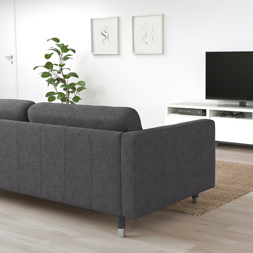 Salón minimalista con sofá gris, mueble de TV y plantas.