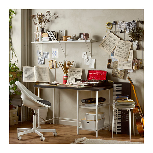 Espacio de trabajo creativo con escritorio SPÄND en tonos neutros, con patas ajustables, varios elementos de decoración e instrumentos musicales.