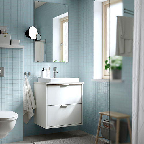 Baño moderno con azulejos azules, espejo grande y planta.