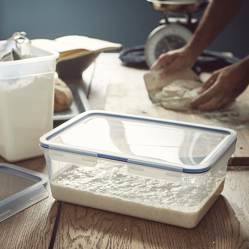 Una persona sostiene masa cerca de un recipiente transparente de comida IKEA 365+ sobre una mesa.