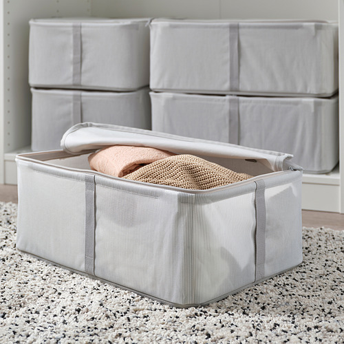 Caja de almacenamiento con tapa, que contiene ropa doblada, apilada ordenadamente para un almacenamiento organizado.