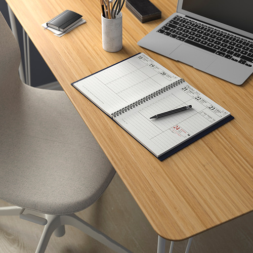 Escritorio de madera con silla gris, cuaderno abierto, bolígrafo, teléfono inteligente y computadora portátil. Espacio de trabajo organizado con estilo moderno.