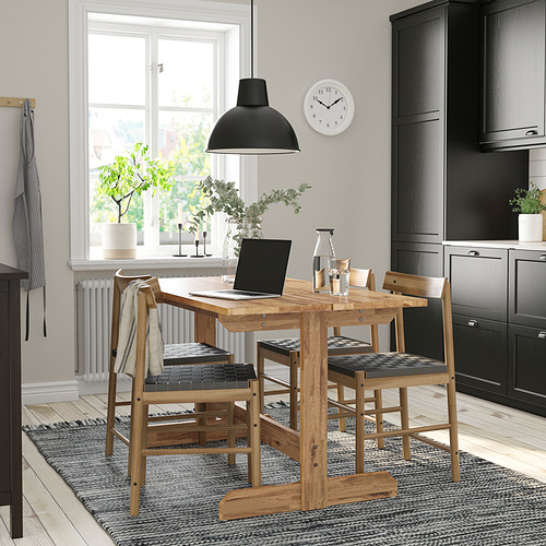 Mesa de comedor NACKANÄS, acacia marrón claro, capacidad para 4-6 personas, diseño rústico, bajo lámpara negra.
