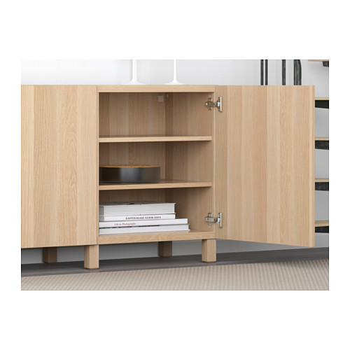 Los estantes de madera clara sostienen libros y un plato, lo que demuestra el almacenamiento y la organización.