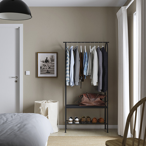 GRÅFJÄLLET perchero negro con barras para colgar y estantes junto a la cama y la ventana.