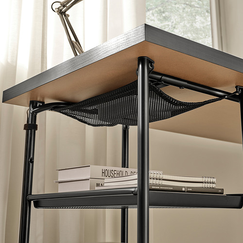 Escritorio de metal negro con estante ajustable para libros y blocs de notas, con gestión de cables debajo del estante.