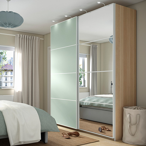 Dormitorio moderno con un gran armario PAX con espejos contra la pared, que complementa la decoración neutra.