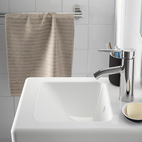 Baño moderno con lavabo TVÄLLEN, grifo cromado, toallero y portacepillos de dientes.