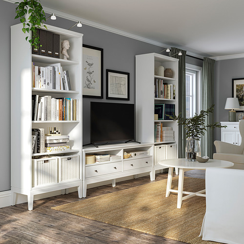 Sala de estar moderna con muebles blancos, paredes grises, suelos de madera y muchos libros.
