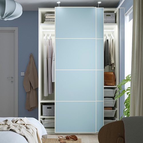 Un dormitorio moderno, un armario PAX azul con puertas correderas, que revela ropa y accesorios organizados en el interior.