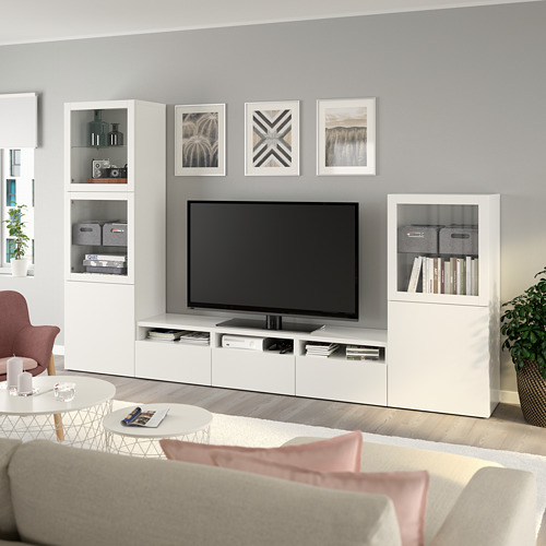 Sala de estar moderna con tv en las unidades BESTÅ, libros, almohadas rosas, diseño minimalista.