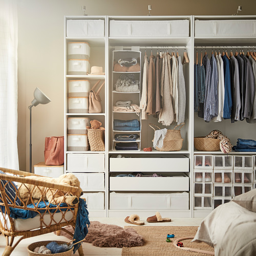 Armario con muebles SKUBB, ropa organizada, silla de mimbre y lámpara.