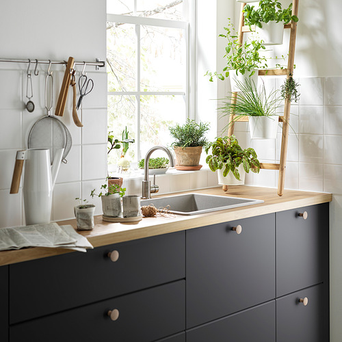Cocina moderna con armarios grises y encimera de madera, pomos VINNÄSET.