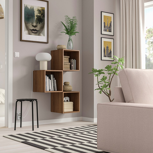Sala de estar moderna con estante de pared de madera EKET, libros y decoraciones.