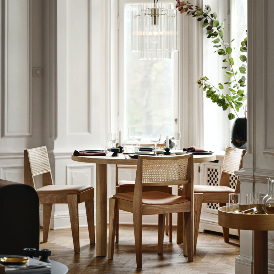 Elegante configuración de comedor con mesa y sillas de roble miel, respaldos de ratán, diseño elegante, espacioso para seis, cerca de una ventana grande.