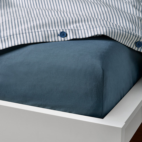 Ropa de cama a juego, rayas azules y color liso, cuidadosamente doblada.