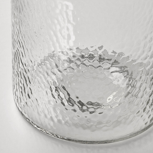 Jarrón de vidrio transparente con superficie texturizada, similar a una burbuja, capturado en un primer plano.