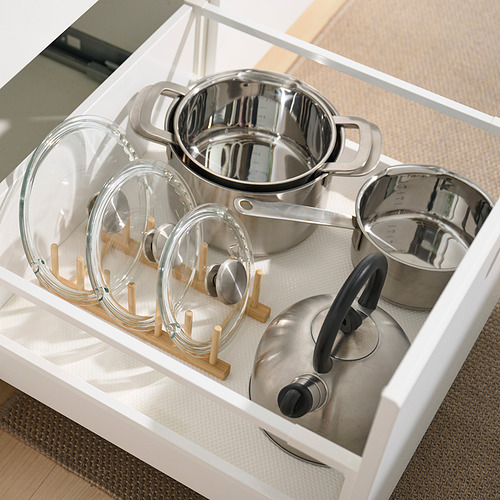Organizador de cajones de cocina con soportes para tapas de bambú y ollas de acero inoxidable.