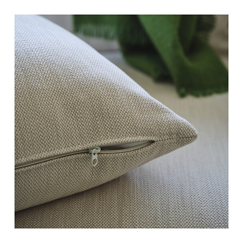 Primer plano de los cojines beige con cremallera en el sofá moderno, enfatizando la comodidad y la funda extraíble.