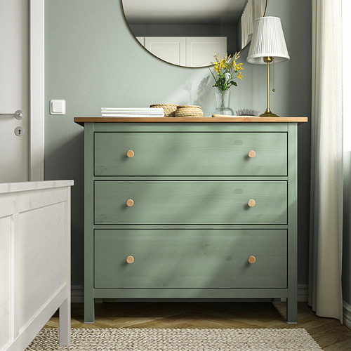 Cómoda HEMNES verde con 3 cajones, encimera de madera, tiradores de latón, lámpara de mesa, espejo.