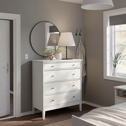 Dormitorio moderno con tocador IDANÄS blanco, espejo redondo, lámpara y percheros. Diseño limpio y minimalista.