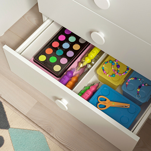 Cajón blanco abierto que muestra materiales de arte para niños: pinturas, marcadores, cuentas, tijeras y cajas de almacenamiento.