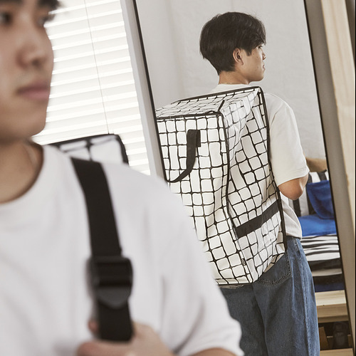 Dos personas muestran bolsos GÖRSNYGG: uno como mochila, correas ajustables; otro por asas, de uso versátil.