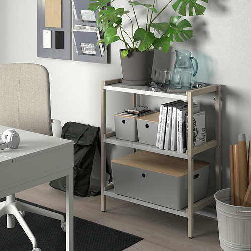 Organizador KUGGIS con libros, plantas y objetos pequeños en un escritorio ordenado con silla y tablón de anuncios.