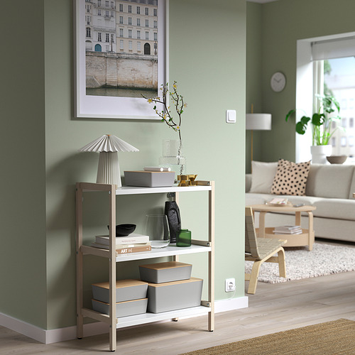 Moderno salón verde con almacenamiento KUGGIS, lámpara, plantas y sofá.