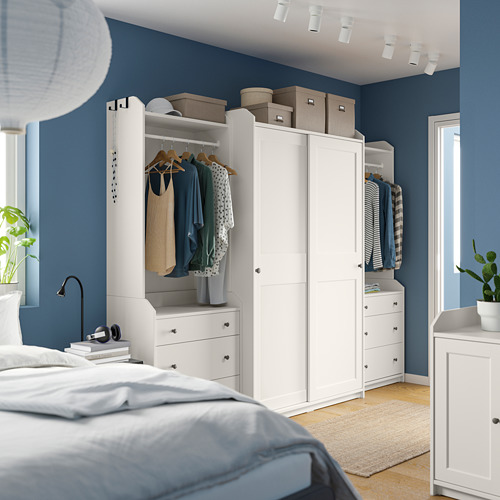 Dormitorio moderno azul con armarios, ropa y plantas HAUGA blancas.