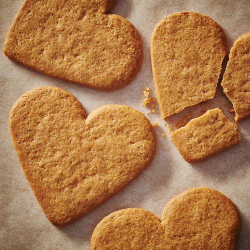 Galletas de jengibre en forma de corazón sobre papel pergamino.