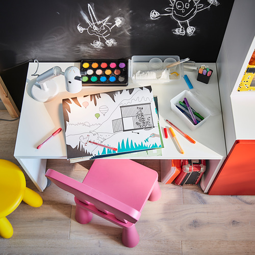 Estación de arte para niños: escritorio blanco, silla rosa, materiales de dibujo coloridos, pared de pizarra.