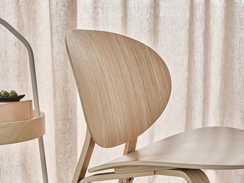 Silla de madera, color claro, respaldo curvo, diseño minimalista.