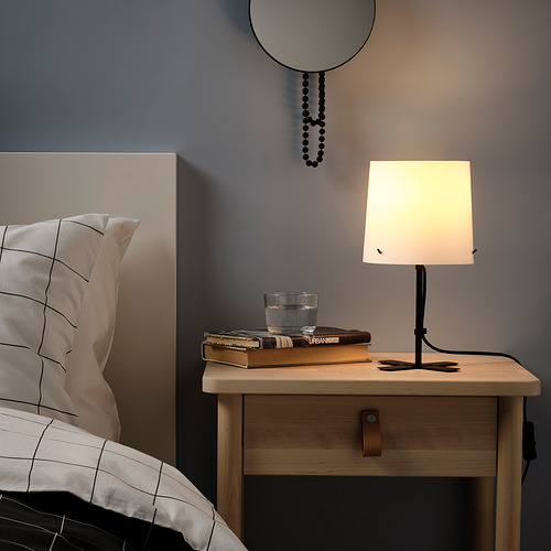 Mesita de noche con lámpara BARLAST, libros, cristal, mesita de noche, cama, almohada de rejilla, pared gris, adorno para colgar.