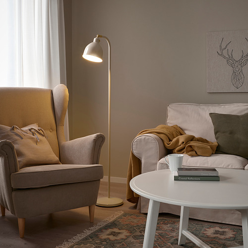 Acogedora sala de estar con lámpara RÖDFLIK, sillón gris y sofá con almohada verde.