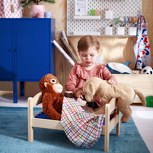 Niña jugando con animales de peluche en habitación colorida