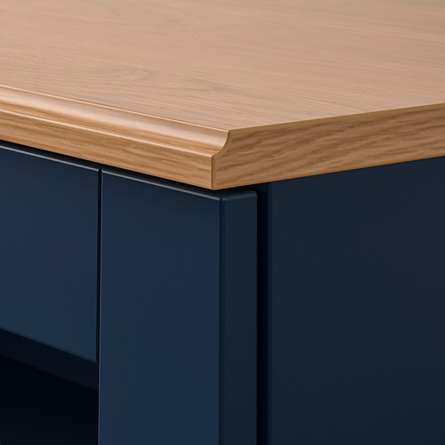 Primer plano de los muebles SKRUVBY Elegante, cálida encimera de roble con bordes elegantes y perfilados y unidad base azul oscuro, que muestra artesanía de alta calidad.