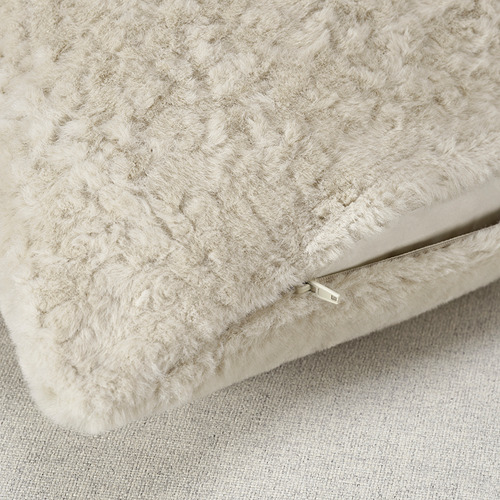 Primer plano de la funda de almohada beige suave y afelpada con cremallera visible, resaltando su textura supersuave y su calidad.