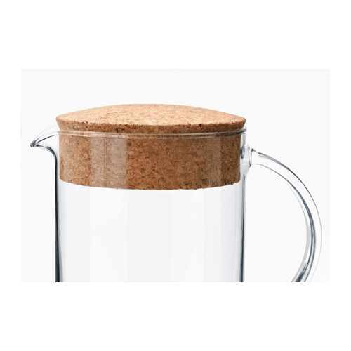 Jarra de vidrio transparente con tapa de corcho resistente, diseñada por IKEA, que muestra calidad y simplicidad.