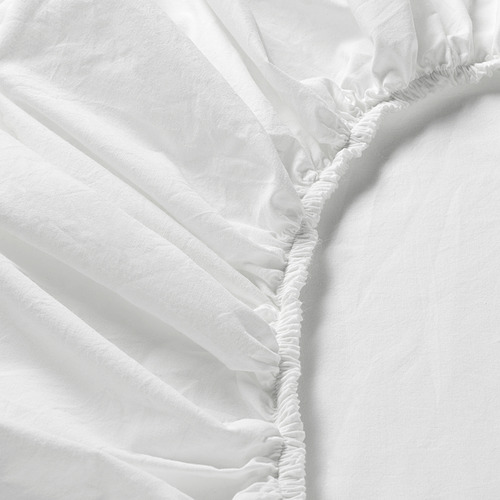 Primer plano de una sábana bajera suave y blanca con bordes elásticos, que muestra su textura suave y uniforme y su artesanía de calidad.
