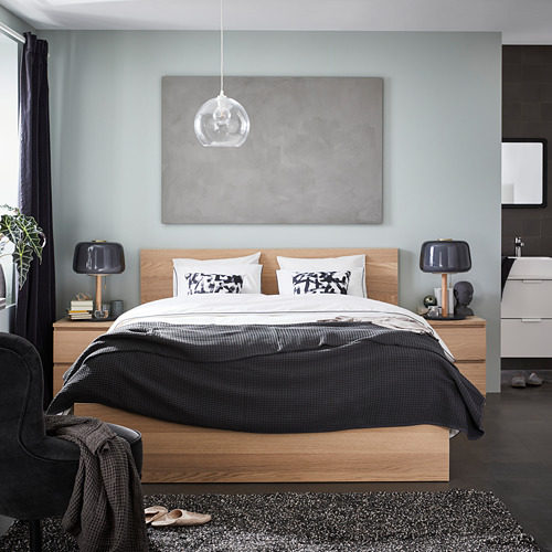 Dormitorio moderno, una cama MALM de madera con ropa de cama gris, mesitas de noche y una gran pintura abstracta.